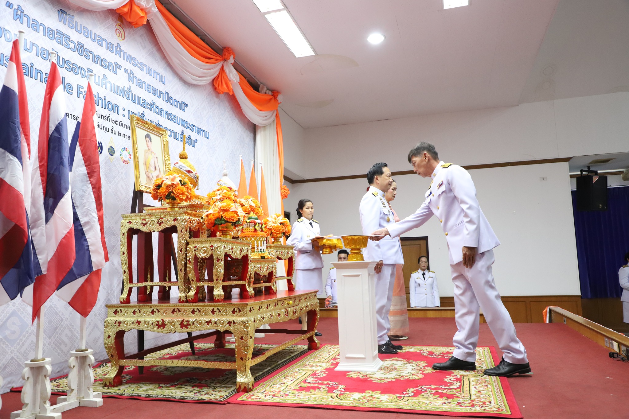 จังหวัดปทุมธานี “จัดพิธีมอบแบบลายผ้าพระราชทาน ผ้าลายสิริวชิราภรณ์ และเครื่องหมายรับรองสินค้าแฟชั่นและหัตถกรรมพระราชทาน : Sustainable Fashion : แฟชั่นแห่งความยั่งยืน ให้แก่ช่างทอผ้า ผู้ผลิต ผู้ประกอบการ นำไปถักทอผสมผสานกับลวดลายภูมิปัญญาพื้นถิ่นตามความคิดสร้างสรรค์ ต่อยอดภูมิปัญญา เพิ่มมูลค่าให้ผลิตภัณฑ์ผ้าไทยและงานหัตถกรรม”